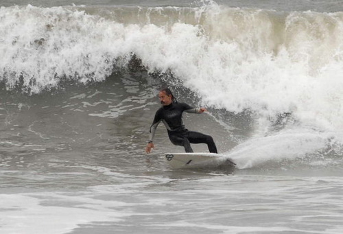 Surfer in wetsuit on wave, surfing backhand