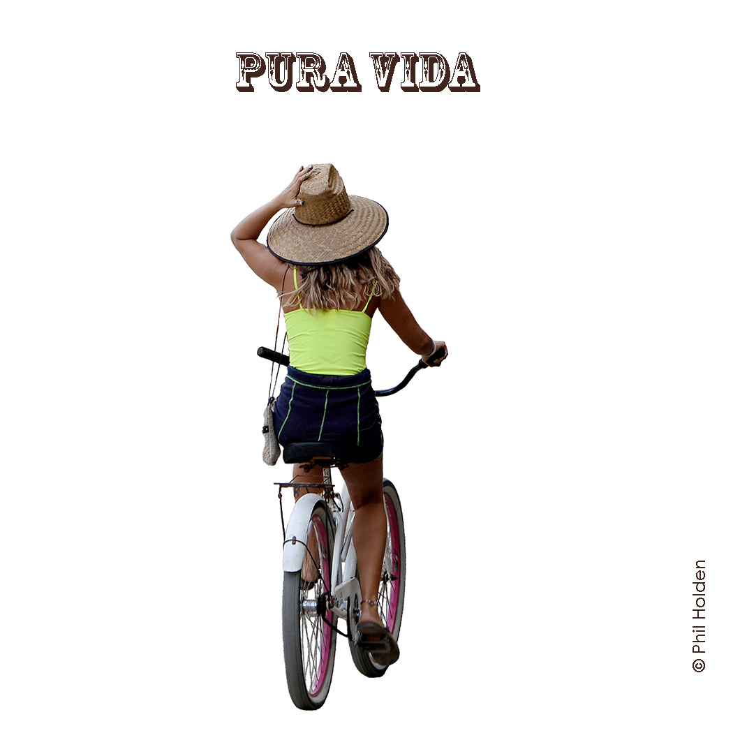 Girl on bicycle holding onto hat