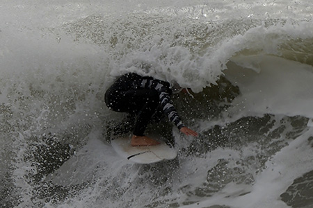 tube ride under frothy lip of wave