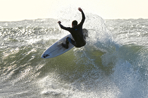 a surfer flies off the lip of the wave